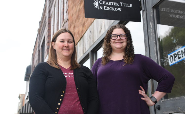 Head of marketing Heather Griffrow (left) and escrow closer Hannah Prusia stand in Charter Title & Escrow in downtown Aurora. The offices have recently been renovated from a photography studio.