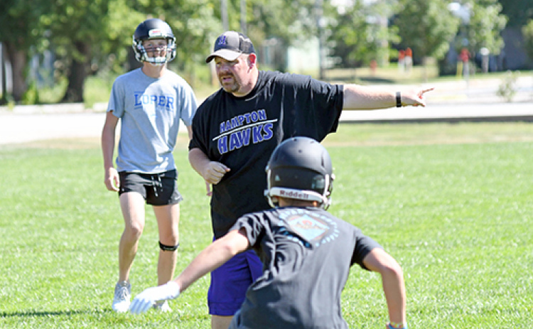 Veteran football coach Jereme Jones, shown here leading the Hawks through preseason workout drills last week, joins the Hampton program after successful stops at St. Edward and Thayer Central.