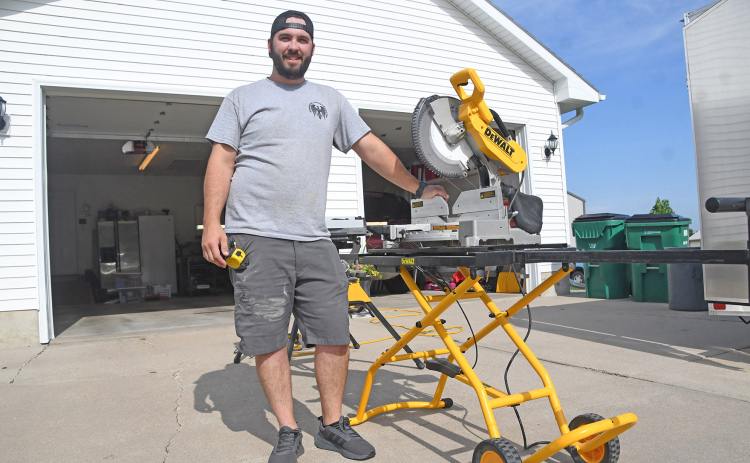 Ryan Freeman, owner and founder of Freebird Construction, LLC, poses in front of his table saw while on a job on 1st Street in Aurora. Freeman has founded his own business after nearly a decade of construction work in Hamilton County.