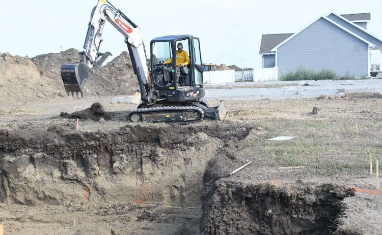 Crews work on a digging a new basement for a single-family dwelling in the Streeter Subdivision Thursday. Two recently poured basements can be seen in the background, represented three of five buidling permits issued for houses last month.
