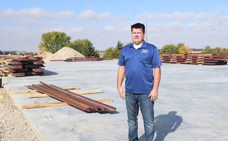 Jason Friesen, owner of Friesen Ford in Aurora, stands on the cement foundation where a new parts distribution warehouse will be built to the north of the dealership. He hopes the facility will be completed “before the snow flies.”
