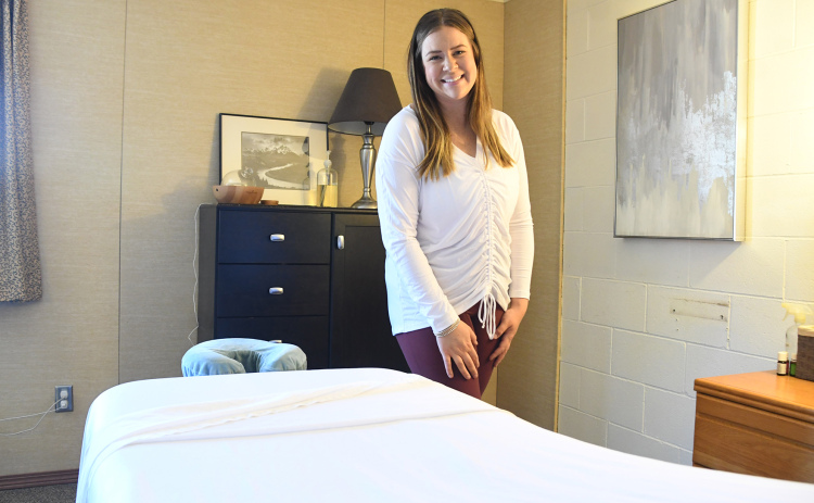 Madison Berthelsen poses behind her massage table in her new office at The Leadership Center. Berthelsen offers massages, facials, waxing and will soon teach yoga classes at Tri-Fit.