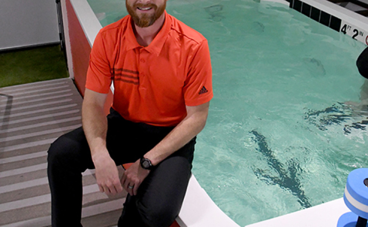 Phil Essliinger sits by the water therapy pool at his new business, Esslinger Physical Therapy, which opened in August on L Street in Aurora.