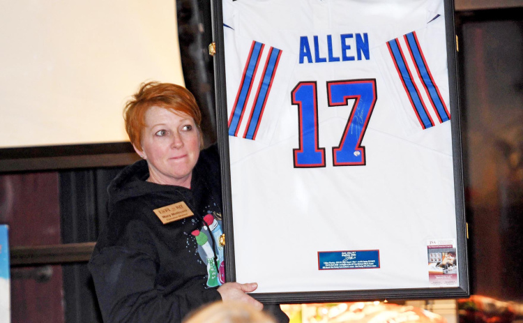 Mary Molliconi holds up a Josh Allen jersey during the live auction Saturday at the Edgerton Explorit Center. The live and silent auction, combined with table sponsorships, raised more than $85,000.