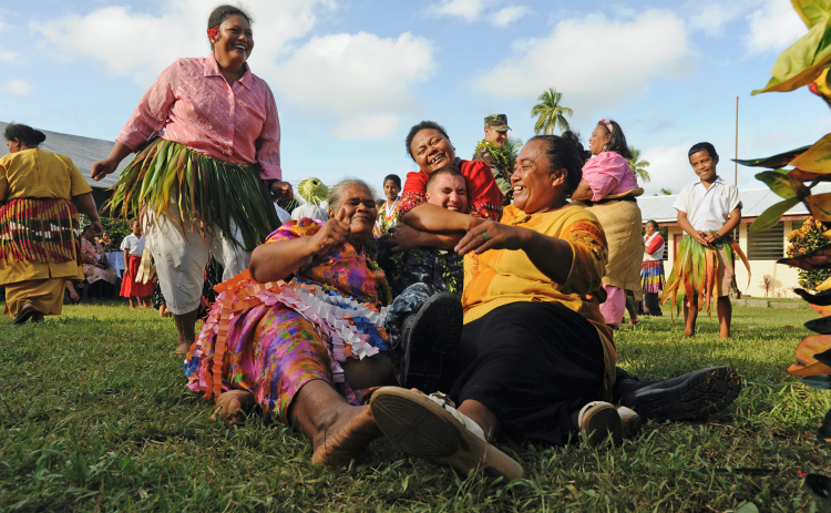 Musician 3rd Class Anton du Preez gets a group hug from the women of the Kingdom of Tonga as part of his 2011 Pacific Partnership tour. The Pacific Partnership is multinational tour that prepares Pacific-bordering nations for national disasters and provides medical assistance since 2004.