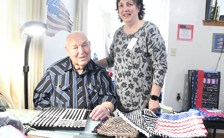 Ramer Fassnacht with his daughter Teresa Elder-Smith and completed hot pad holders, with one in progress, on the table at his apartment in East Park Villa. Fassnacht makes up to 20 a week and his daughter helps finish them and works with her two sisters to sell his creations.