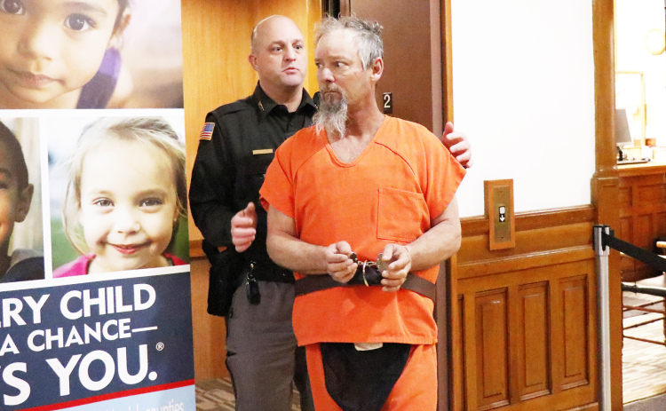 Hamilton County Sheriff Jeromy McCoy escorts murder suspect Jeffrey Adams into county court Tuesday morning.