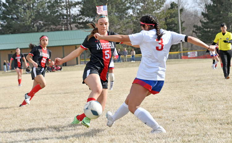 Aurora’s Madisyn Willis tries to get around a Crete defender with the ball in the first half of a 4-0 win against the Cardinals Thursday.