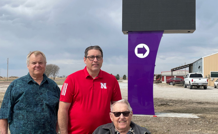 Pictured from left in front of the new Hampton school sign on Highway 34 are Kevin Wall of Hampton, Mike Wall of Forney, Texas and Denny Wall, who now lives in York. Denny and his wife Beverly donated funds to launch the sign project.