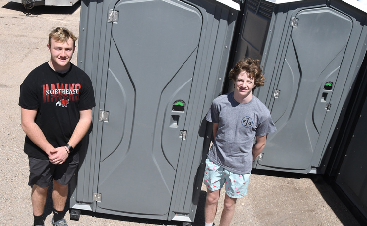 Karson, left, and Caden Meyer stand next to some of their 18 porta potties that can be rented out from their business, C and K Potties. The two high schoolers started the venture this year and have already found success with construction companies and providing for events.