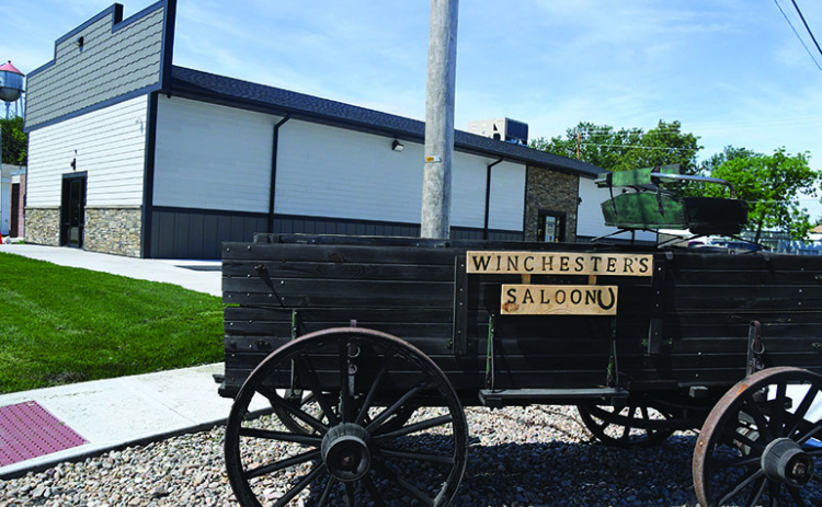 A wagon with the name of the new restaurant in Phillips sits next to the structure itself with the Phillips water tower in the distance. The saloon had a soft opening May 3 and will host a grand opening June 13 at 5:30 p.m.