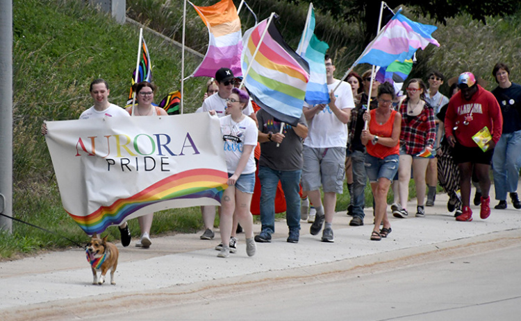 A group of approximately 40 people carried a banner and waved rainbow-colored flags along Highway 14 during the third annual Pride march Saturday in Aurora.