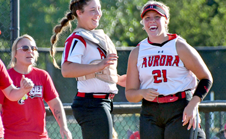 Aurora’s Kaelin Sparr (left) and Sydney Thomas celebrate after the softball team’s 15-0 win over Lexington Thursday.