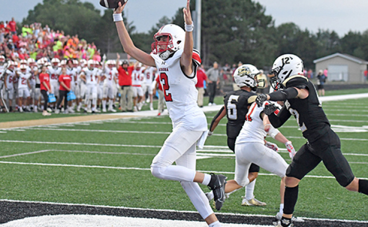 Booker Scheierman throws his hands up after one of his seven total touchdowns in Aurora’s 50-30 win over Grand Island Northwest Friday.