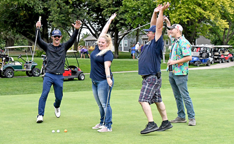 Tiffany Luebbe sunk a putt during Friday’s MCHI golf benefit, setting off a celebration amongst team members, from left: Dalton Chasting, Eric Smith and Chris Hyde.