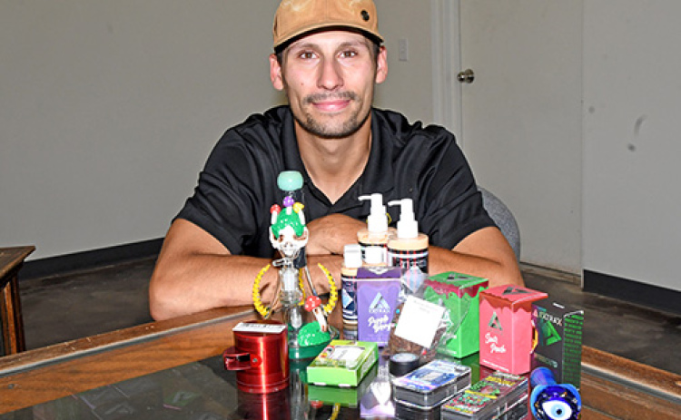 Jordan Oliva-Harring displays some of the cannabinoid inventory now available at High Vibe Spiritual Wellness on 9th Street in Aurora.