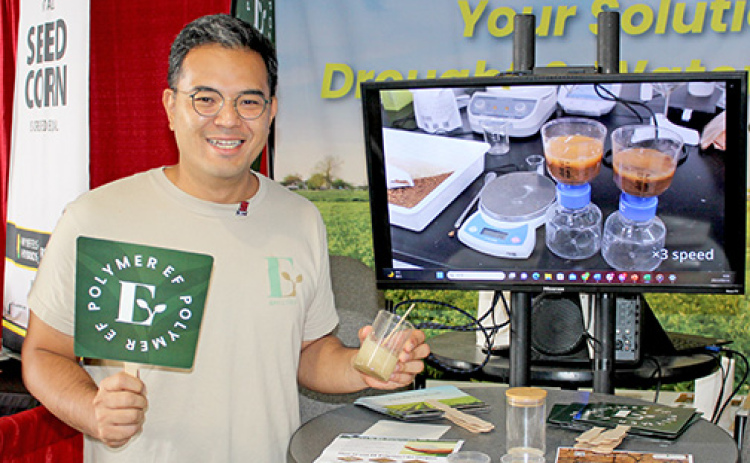 Kuni Shimoji, COO of Japan-based EF Polymer, shows off his product at the company’s booth at this year’s Husker Harvest Days. The product made from discarded orange and banana peelings promises to hold moisture in the soil and boost yields.