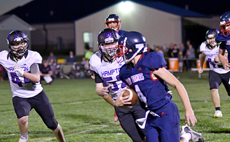 Hampton’s Bryce Joseph (44) and Tyler Mollevik (52) give chase during the first half of the Hawks’ 77-20 win at Heartland Lutheran Thursday.