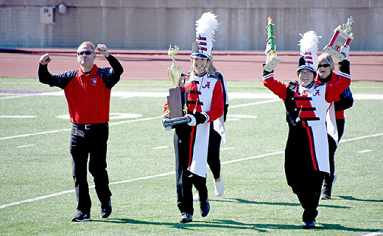Band directors and drum majors hold their heads high as they showcase the hardware they won, moments after hearing the results at Saturday’s Harvest of Harmony competitions.
