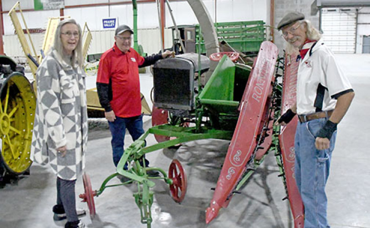 Pictured from left, Donelle Moormeier, Scotty Andreasen and Howard Raymond, all members of the International Harvester Collectors organization, inspect an antique combine at the Plainsman Museum as part of their Saturday meeting in Aurora.