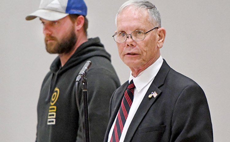 Former Hampton teacher Marlin Seeman leads those attending the Hampton Veterans Day Program through a ceremony for the proper disposal of a faded American Flag. Looking on is Aurora native Austin Allen.