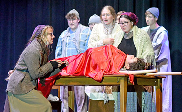 Cast members react during an emotional scene while Bartley, a lead character in “Riders to the Sea” played by Sam Elge, lies dead on the table.
