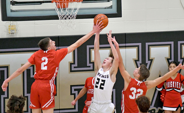 Aurora’s Booker Scheierman swats the shot of Dawson Urbanski as part of the Huskies’ 45-40 win on the road Saturday. Scheierman blocked two shots in the game.