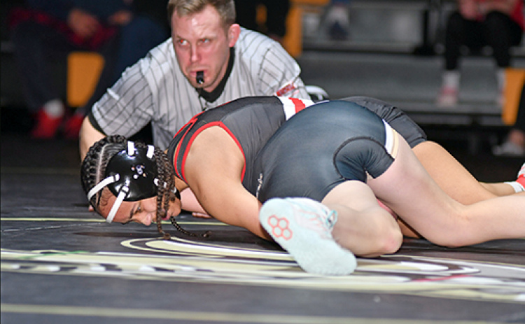 Aubrie Beed rolls over for the pinfall victory during Aurora’s dual against Grand Island Northwest last week. The Aurora junior has gone through the first month of the season with an undefeated mark.