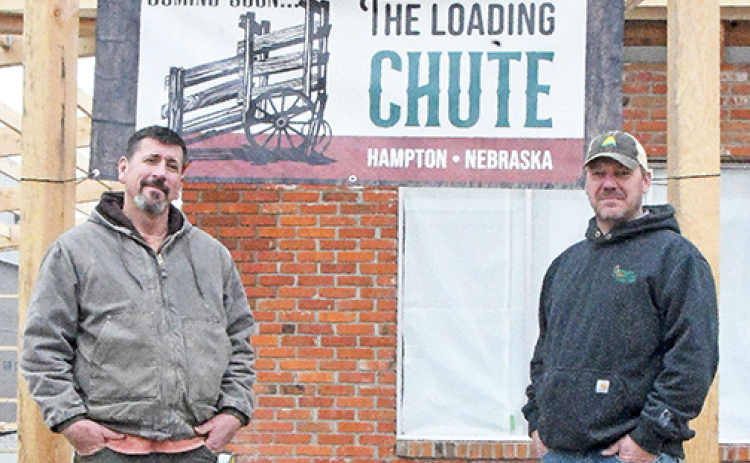 Hampton residents Ryan Bamesberger, left, and Grant Dose, representing two of the three couples involved in starting the Loading Chute restaurant and bar, stand outside the former Hampton Legion Hall which is being transformed into a new hometown cafe for the village.