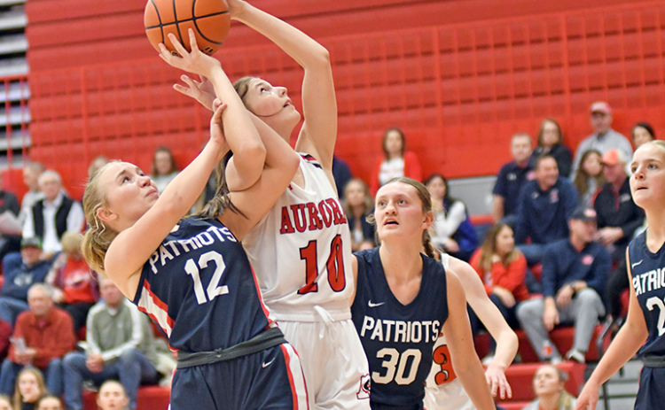 Kenna Merrihew gets twisted up with multiple defenders in the paint during Aurora’s 58-34 loss to Adams Central Thursday.