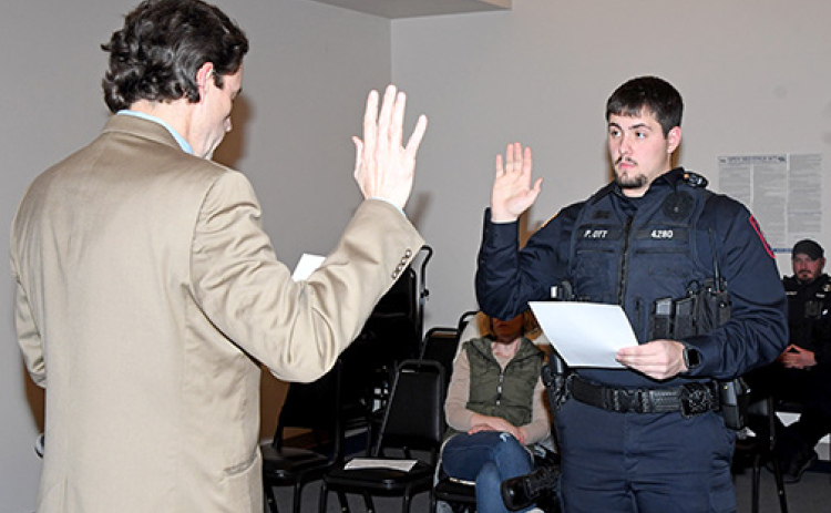 Peyton Ott takes the oath of office last week, beginning his tenure as a member of the Aurora Police Department. Administering the oath is Aurora City Attorney Ross Luzum.