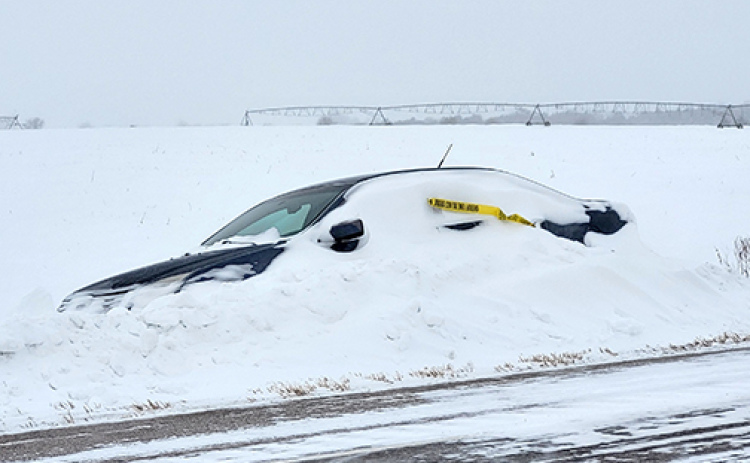 This car seen abandoned along Highway 14 Monday morning about a mile north of the Marquette turnoff was one of more than a dozen vehicles abandoned in the county over the weekend, according to County Highway Superintendent Jeremy Brandt. Their drivers had to be rescued by highway department workers and deputies after they got stuck in the snow.