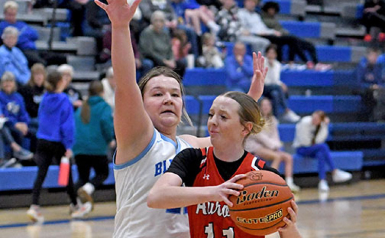 Aurora junior Adi Fahrnbruch drives the lane against Ashland-Greenwood’s Reaghan Craven. Fanrnbruch hit a buzzer-beater at the end of regulation to help the Lady Huskies advance.