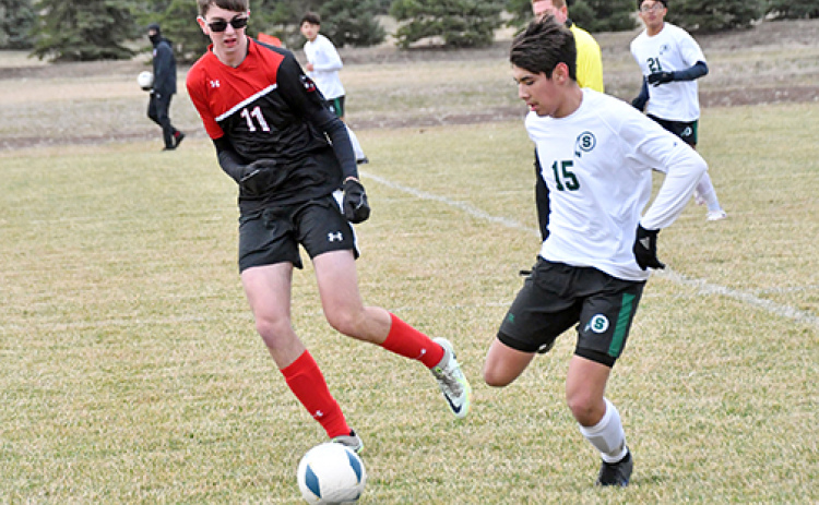 Aurora’s Thomas Brandl tries to slow down the Schuyler offense in the midfield during Thursday’s home opener.