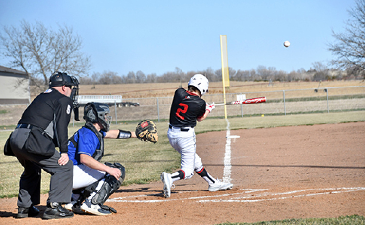 Aurora’s Keelan Phillips pulls the baseball down the line during the Huskies’ 13-3 loss at Centennial last week in the program’s first-ever high school game.