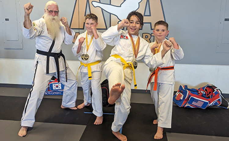 Seven students of Aurora’s ATA Martial Arts got off on the right foot in their first competition, placing and medaling at the Lincoln Gold Star Martial Arts Class C Tournament. From left, Master Vern Larson and students Jonah Sigears, Adrik Diaz and Gage Bright kick up their heels as they celebrate their first successful competition.