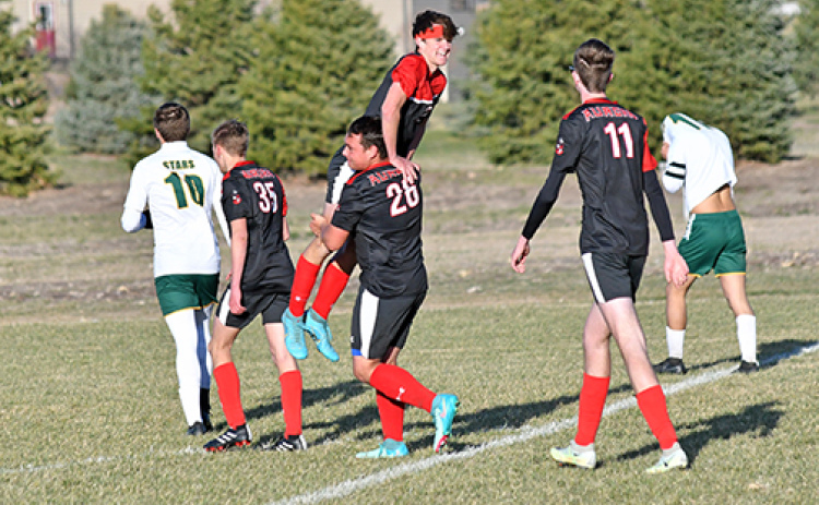 Jeryn McClain lifts Canon Allen onto his shoulders in celebration after the Huskies scored the game-winning goal with five minutes left to defeat Kearney Catholic, 3-2.