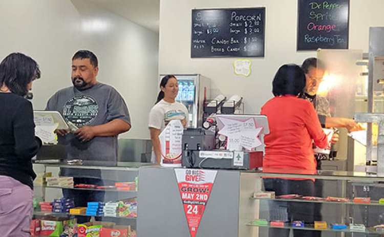 Volunteers from Ramon’s Tile work the concessions stand at 12th Street Cinema on a recent weekend.