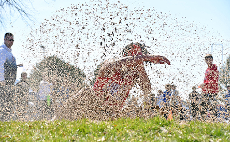 Vendell Juyzk is somewhere behind this large spray of sand during one of his long jump attempts at Thursday’s Norris track and field championships. Juyzk finished second in both the long and triple jump events.