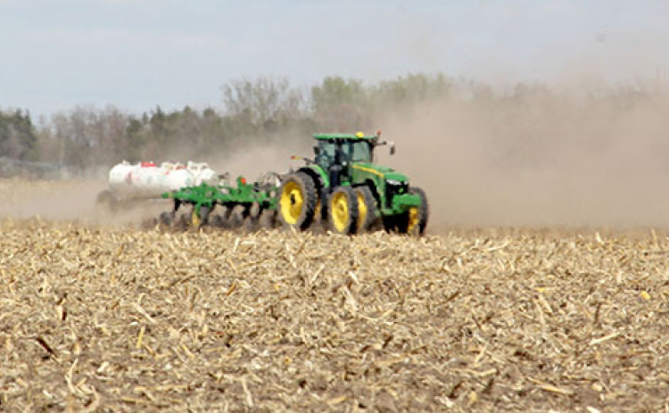 Dust and heat waves blur the view of this tractor as it works in a field in northern Hamilton County on April 20. Planting operations were often accompanied by large clouds of dust as seeds were sown in the dry soil before the recent rains.