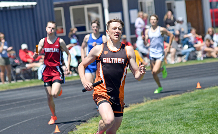 Phillip Kreutz rounds the first turn on the final lap with the field chasing him as the Hornet senior led the 3200 relay group to a win at the D-6 district in Kenesaw.