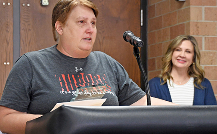 Aurora High School teacher Brenda Klawonn speaks to school staff on Friday afternoon after being presented with the 2024 William C. and Delight M. Eloe Award by Tammy Morris of the Hamilton Community Foundation (right).