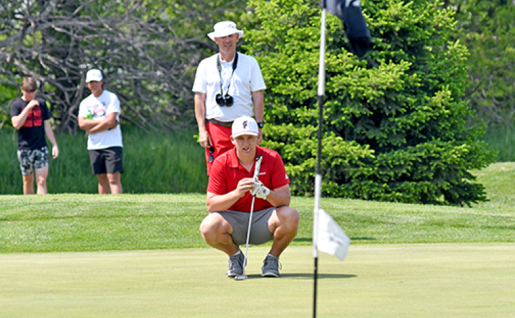 Luke Grosshans, shown here reading a putt with some assistance from coach Craig Badura at districts, finished tied for 28th at the Class B state golf meet.