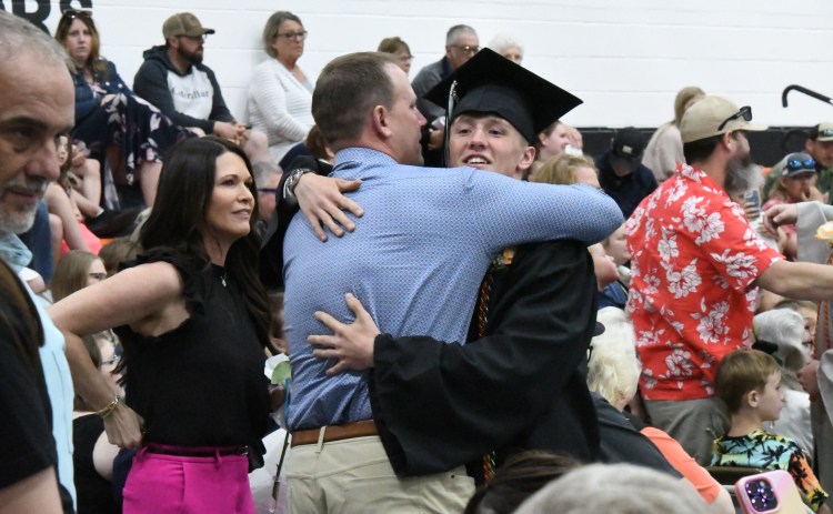 During the exchange of roses from the graduating seniors and their family members, Phillip Kreutz embraced his father Jim. Alongside his father his mother, Jaime.