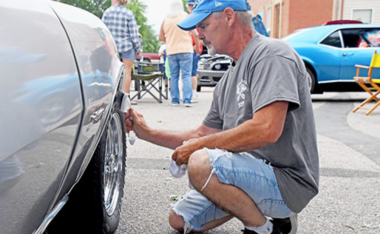Gary Holling from Superior washes off the wheel of his silver 1968 Chevy Camaro at the Giltner Daze Car Show on Saturday.