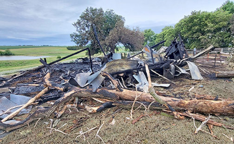 What remained of Tom Oswald's century-old barn on Wednesday morning after a fire started by electrical wires burned it to the ground Monday, June 17.