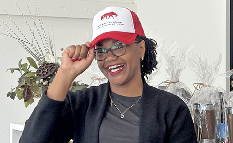 Roseline Njogu, Principal Secretary with the Kenya State Department for Diaspora Affairs, is all smiles as she puts on an International Workforce Services cap during a trade delegation visit to Aurora Friday. The hat was part of a gift exchange between the Aurora hosts and guests from Kenya.