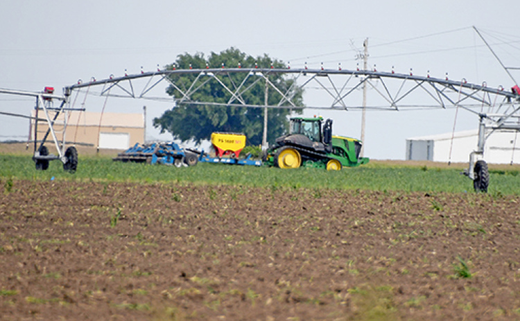A farmer takes advantage of a window between thunderstorms to do some field work south of Aurora Thursday afternoon. Local observers say that despite the frequent rain showers in May, planting appears to be nearly complete in Hamilton County.