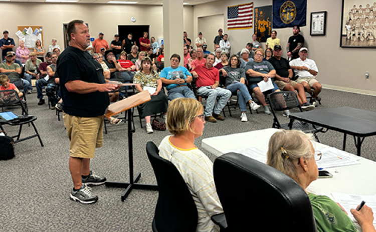 Randy Beckman speaks to the Marquette Village Board during Monday’s public hearing regarding a controversial sign issue.
