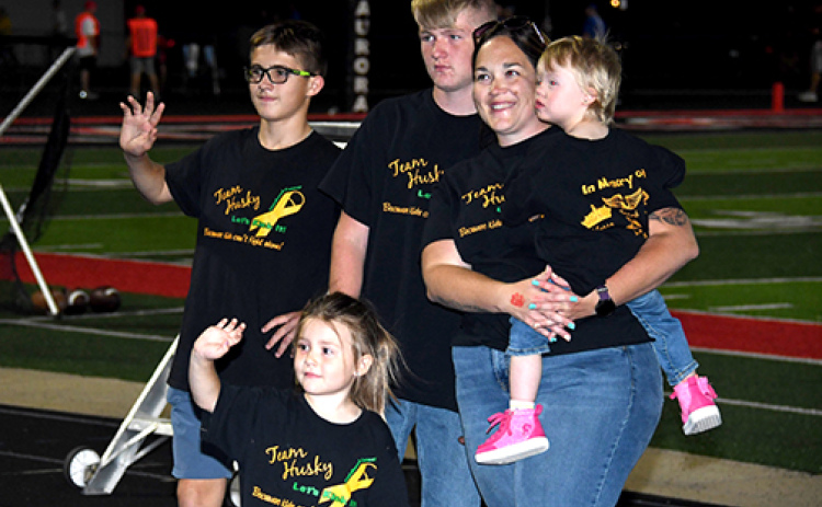 Melissa Widner holds her daughter, Bailey, during Friday’s half-time PCAN presentation. Bailey is now in remission, a year after the family received proceeds from the Aurora PCAN donation night in the midst of her battle against cancer.